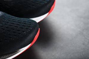svart löpning skor med maska och svart skosnören närbild på en mörk bakgrund foto