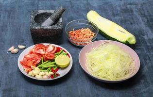 friska mat ingrediens papaya sallad eller as tum thai på trä bakgrund. foto