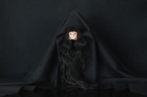 skrämmande svart Färg spöke kostym bära kvinna docka huvud. halloween begrepp. foto