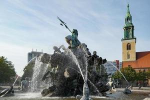 berlin, Tyskland - september 15, 2014. se av de neptune fontän med marienkirche i de bakgrund i berlin på september 15, 2014. tre oidentifierad människor foto