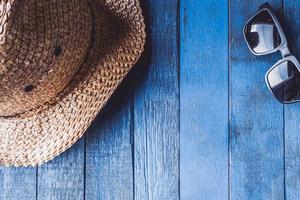 hatt med solglasögon på blå målad trä planka bakgrund.. fri Plats för text foto