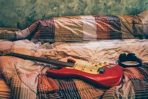 elektrisk gitarr och hörlurar i sovrum, filmer spannmål filtrera. foto