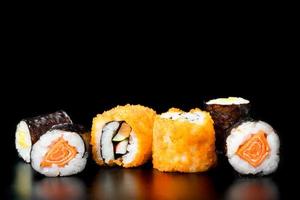 sushi rullar på svart bakgrund, japansk mat. foto