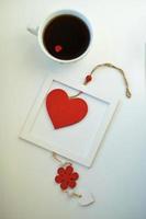 kopp kärlek, kaffe med rött hjärta. rött hjärta på ett rep i träramen. alla hjärtans dag. morgon. den 14 februari. foto