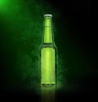 öl flaska med vatten droppar på de grön Färg rök bakgrund foto