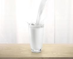 häller mjölk in i glas kopp med stänk, på trä- tabell foto