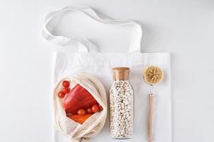 färsk grönsaker, bönor i en glas flaska och textil- handla väska foto