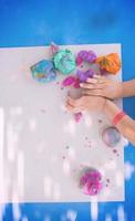 barn händer som leker med färgglad lera foto