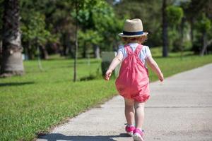 liten flicka springer i sommarparken foto