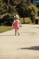 liten flicka springer i sommarparken foto