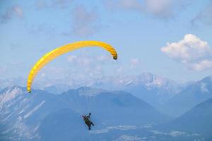 paraglider stigande i de blå himmel över de skön berg. foto