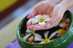 kvinnlig hand och blomma i vatten foto