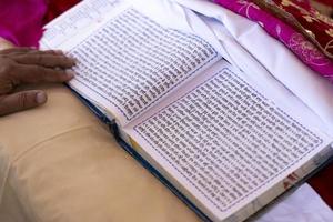 guru granth sahib helig religiös skriften av sikhism. punjabi språk skriven på religiös vit sidor i bröllop ceremoni. foto