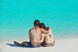 Lycklig ung par njuter sommar på strand foto