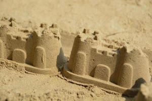 2 sand slott små storlek på de strand. foto