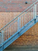 stänga upp se på metallisk trappa i främre av en tegel vägg. foto