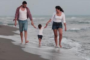Lycklig ung familj ha roligt och leva friska livsstil på strand. selektiv fokus foto