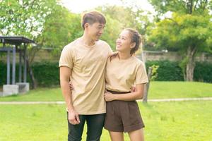 asiatiskt par älskar att dejta i parken foto