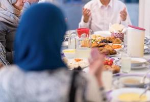 modern multietnisk muslim familj bön- innan har iftar middag foto