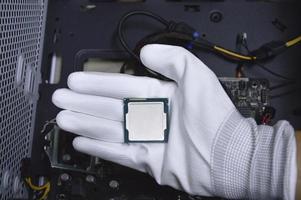 bild av en hand bär vit handskar med en cpu chip placerad på Det. foto