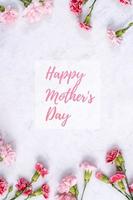 Lycklig mors dag bakgrund design begrepp med hälsning ord, skön rosa, röd nejlika blomma bukett på marmor tabell, topp se, platt lägga, kopia Plats. foto