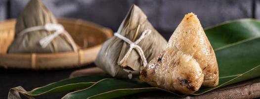 ris dumpling, zongzi - kinesisk ris dumpling zongzi på svart tegel bakgrund skiffer bord, begreppet drakbåt festival traditionell mat, närbild. foto