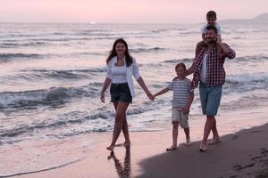 familj sammankomster och umgänge på de strand på solnedgång. de familj promenader längs de sandig strand. selektiv fokus foto