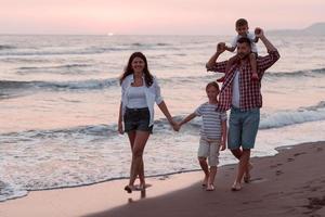familj sammankomster och umgänge på de strand på solnedgång. de familj promenader längs de sandig strand. selektiv fokus foto