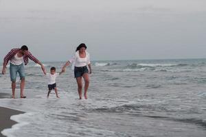 Lycklig ung familj ha roligt och leva friska livsstil på strand. selektiv fokus foto