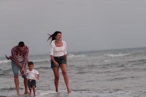 de familj åtnjuter deras semester som de promenad de sandig strand med deras son. selektiv fokus foto