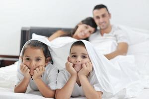 Lycklig ung familj i deras sovrum foto