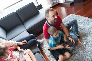 Lycklig familj spelar en video spel foto