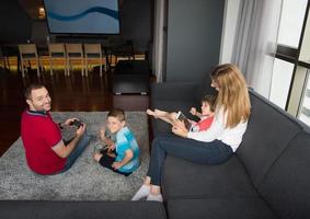 Lycklig familj spelar en video spel foto