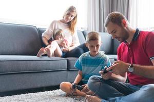 Lycklig familj spelar en video spel foto