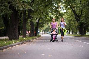 kvinnor med bebis sittvagn joggning tillsammans foto