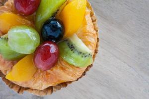 närbild danska bakverk med frukt på träbord foto