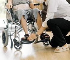 läkare eller sjuksköterska vårdgivare med senior man i en rullstol bär skyddande masker på Hem eller amning Hem foto