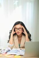 vuxen kvinna med huvudvärk arbetssätt på bärbar dator i kontor foto