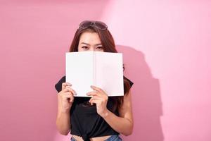 bild av skön ung Söt kvinna Framställ isolerat över rosa bakgrund vägg innehav bok läsning. foto