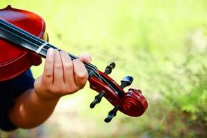 elementärt skola pojke spelar de fiol i de trädgård. musik utbildning begrepp. kopia Plats foto