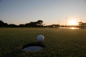golf boll på kant av de hål foto
