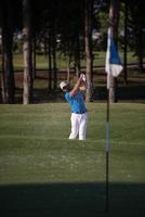 proffs golfspelare slå en sand bunkra skott foto