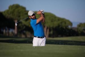 proffs golfspelare slå en sand bunkra skott foto