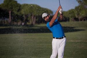 proffs golfspelare slå en sand bunkra skott foto