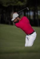 golfspelare slå en sand bunkra skott foto