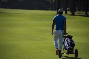 golf spelare gående med hjul väska foto