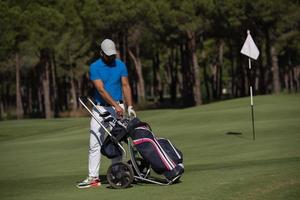 golf spelare gående med hjul väska foto