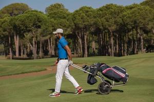 golf spelare gående med hjul väska foto
