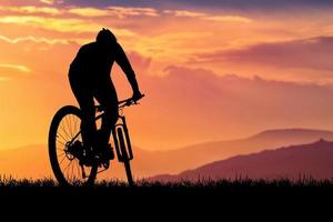 siluett av mountainbikecyklister med vacker utsikt. cykel träning koncept foto