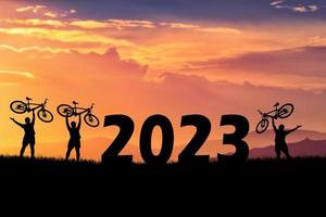 cykeläventyrliga turister som bär cyklar över hinder. gott nytt år 2023 foto